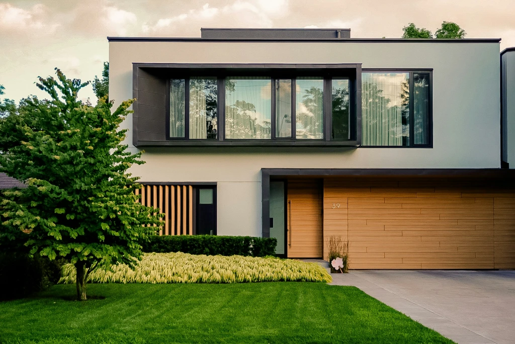 Modern two-story home with expansive windows showcasing how custom plantation shutters can complement contemporary architecture while providing privacy and light control.