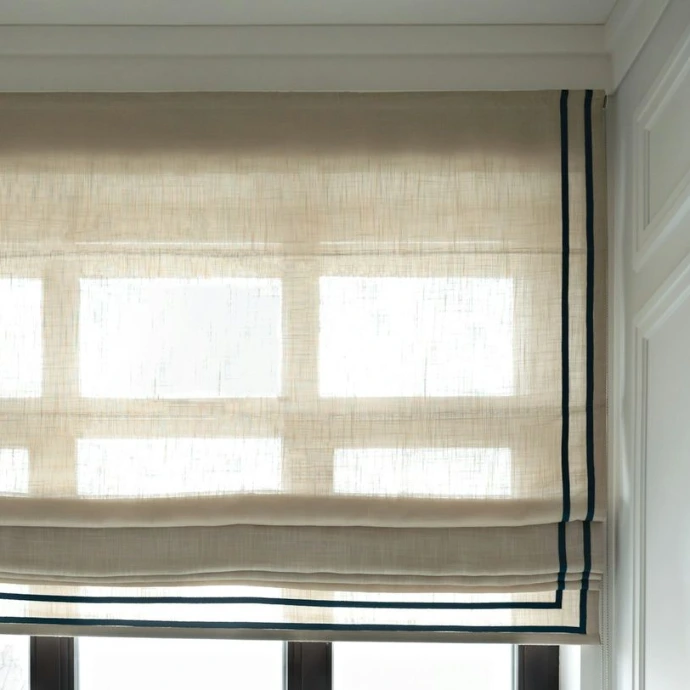 Custom fabric Roman shades with elegant horizontal folds and decorative trim, adding softness, privacy, and timeless style to interior windows.