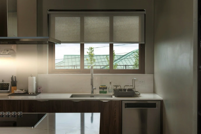 Custom rller shades installed in a modern kitchen, providing light control, privacy, and a clean, contemporary look for interior windows.