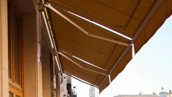 Retractable fabric awnings with sturdy support arms extending over an outdoor space, providing adjustable shade, sun protection, and comfort.